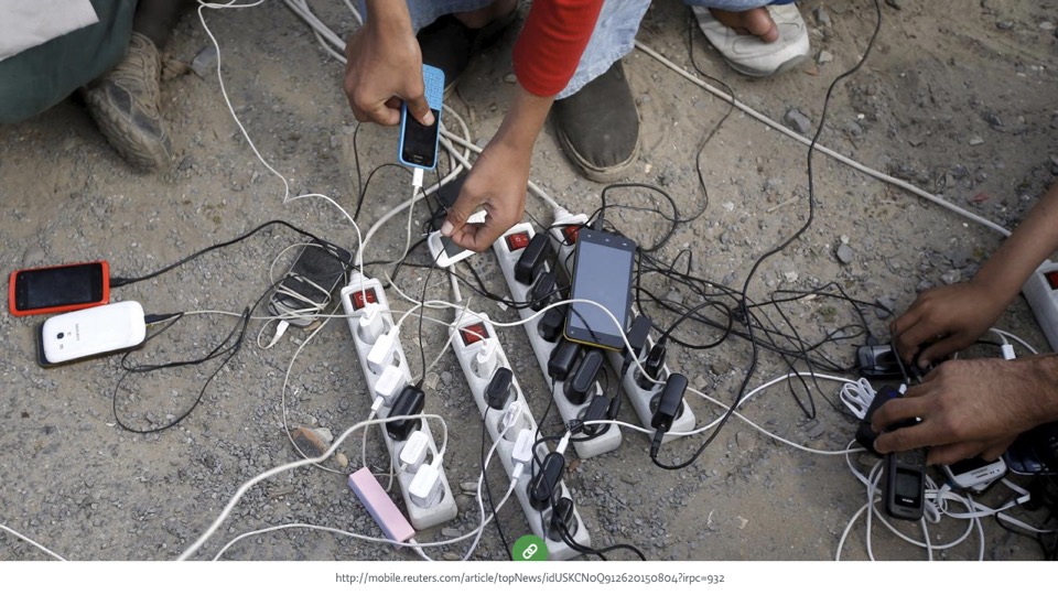 closeup of several people charging their smartphones